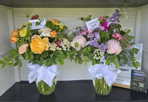 Two garden vase arrangements tied with white bows
