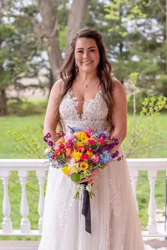 Bride holding her bright garden bouquet on a porch